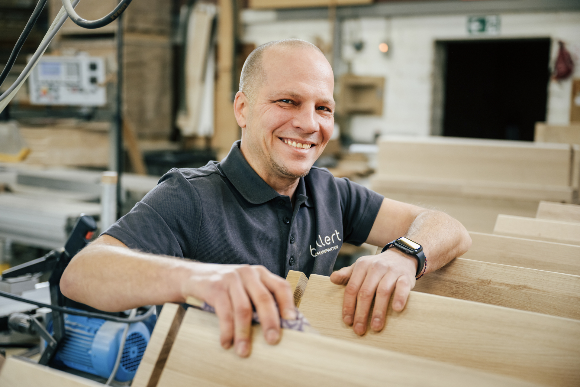 Schreinergeselle beim Schleifen einer Treppe aus Eichenholz in der Werkstatt